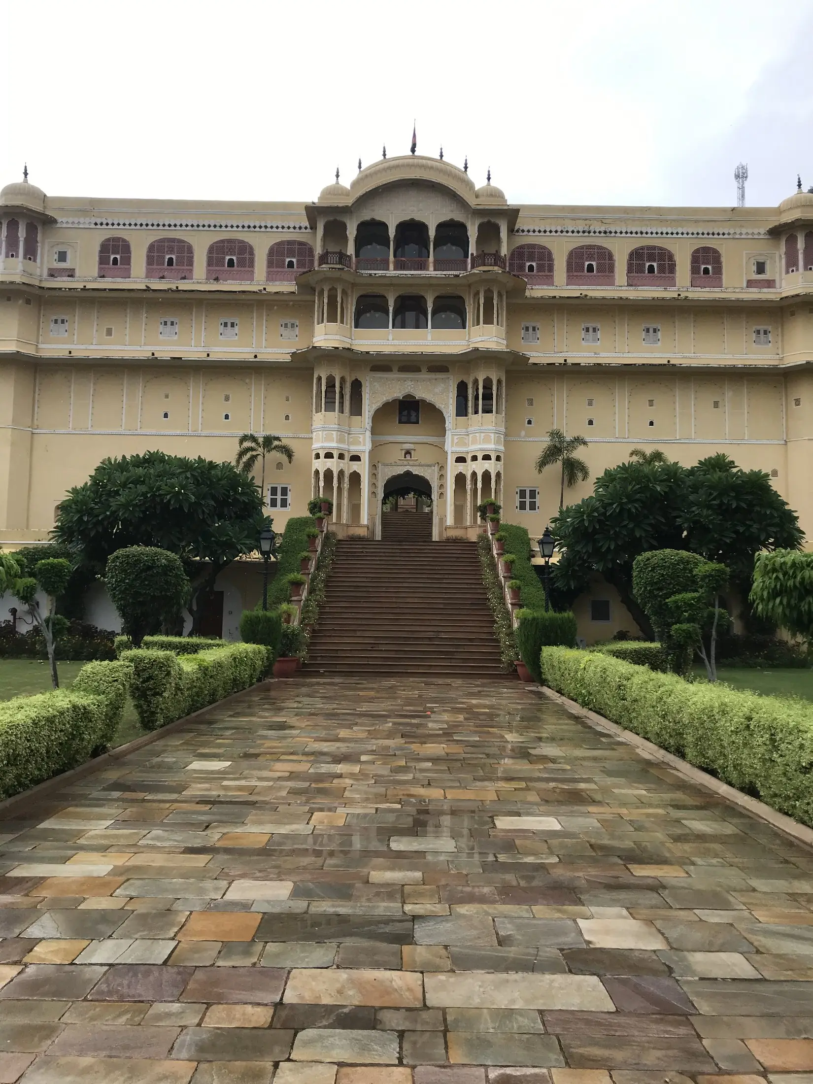 Heritage palace hotel in Rajasthan with a stone pathway and manicured gardens